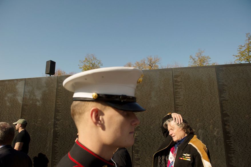 Veterans and current service members walks along past the names on the wall at the Vietnam Veterans Memorial during Veteran's Day weekend in Washington, D.C. (Rod Lamkey Jr./The Washington Times)