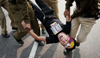 Indian police detain a Tibetan Youth Congress supporter protesting outside the Chinese Embassy in New Delhi on Monday. China has blamed the Dalai Lama for the glorification of a wave of self-immolations among Tibetans. (Associated Press)
