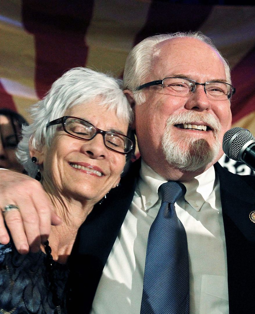 Democratic Rep. Ron Barber of Arizona hugs his wife, Nancy, on Election Day. Mr. Barber has pulled ahead of challenger Martha McSally by almost 700 votes after the Republican led by less than 500 votes in the days immediately after the election. (Associated Press)