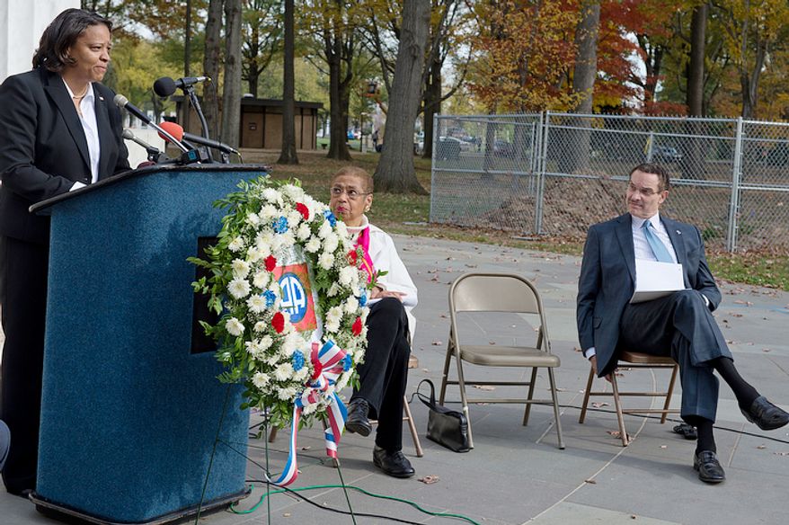 Congresswoman Eleanor Holmes-Norton, center, and Mayor Vincent Gray look on as Tomi Rucker, a Washington, D.C. Navy mom, talks about how she and her husband were saddened by the fact that the D.C. flag was not a part of her son's Navy boot camp graduation, when flags from the other states with graduates were present. Ms. Rucker joined the D.C. officials at the D.C. World War I Memorial on Monday, Nov. 12, 2012 to talk about the inconsistent flying of the D.C. flag at military graduations. (Barbara L. Salisbury/The Washington Times)