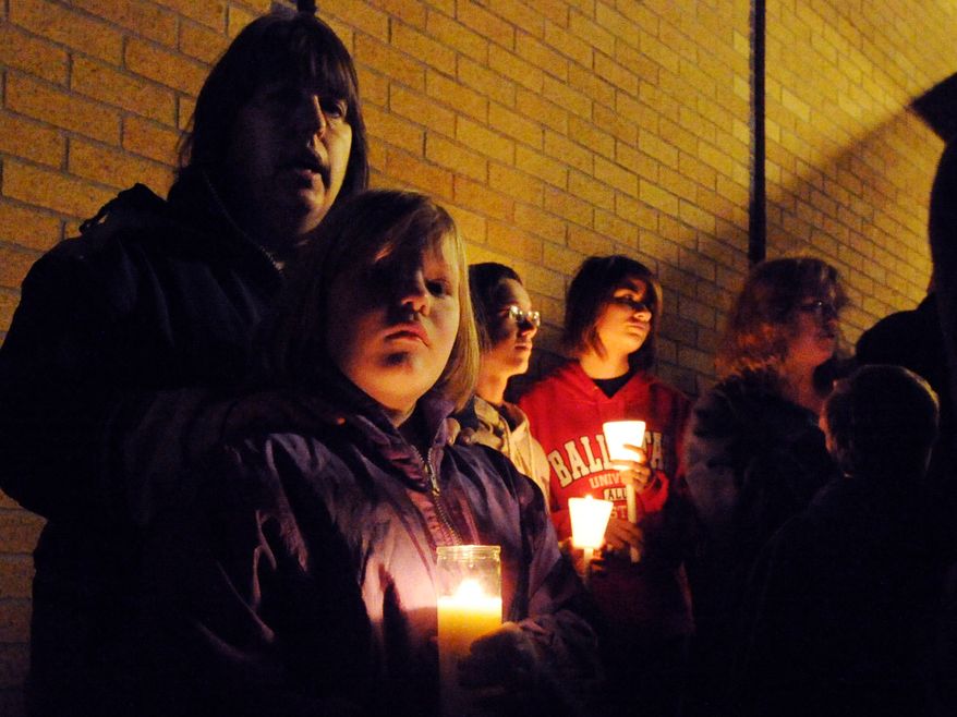 Ahna McCue and her daughter, Emily, attend a candlelight vigil on Nov. 11, 2012, at Southwest Elementary School in Greenwood, Ind., for second-grade teacher Jennifer Longworth. Officials did not identify the two people who were killed in a blast the previous day. However, a candlelight vigil was held for Longworth. She and her husband, John Dion Longworth, lived at a home destroyed in the blast. (Associated Press/The Indianapolis Star)