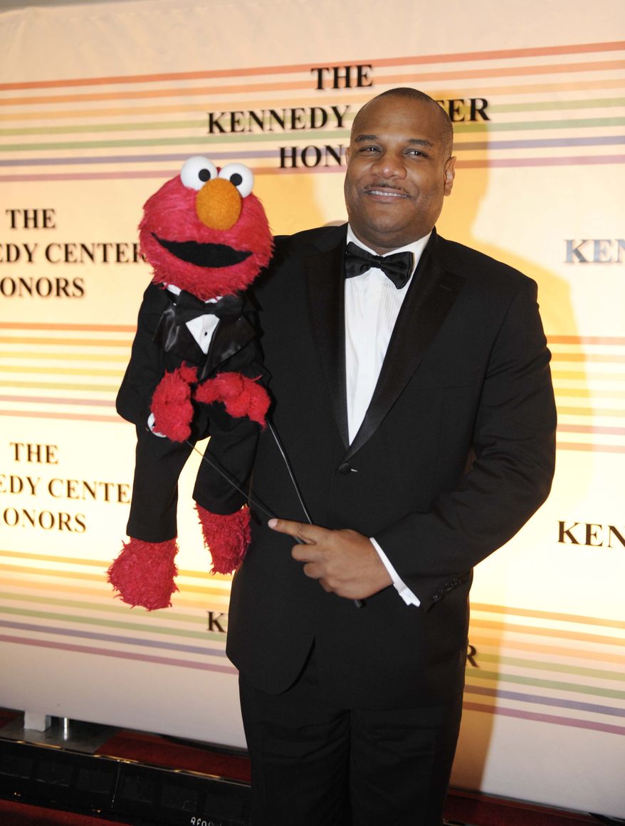 FILE - In this Dec. 4, 2011 file photo, Elmo puppeteer Kevin Clash arrives with the "Sesame Street" muppet at the Kennedy Center for the Performing Arts for the Kennedy Center Honors gala performance in Washington. The man who accused Clash of having sex with him when he was a teen now says it isn't so. The man said in a statement released on Tuesday, Nov. 13, 2012 that his sexual relationship with Clash was adult and consensual. (AP Photo/Kevin Wolf, File)