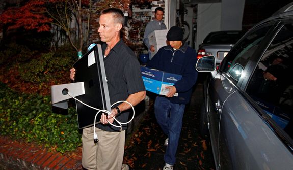 FBI agents carry boxes and a computer from the home of Paula Broadwell, the woman whose affair with retired Gen. David Petraeus led to his resignation as CIA director, in the Dilworth neighborhood of Charlotte, N.C., on Nov. 13, 2012. (Associated Press)