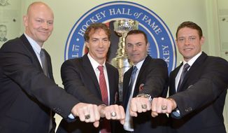 Hockey Hall of Fame inductees, from left, Mats Sundin, of Sweden, Joe Sakic, Adam Oates and Pavel Bure, of Russia,  pose for a photograph with their rings at the Hockey Hall of Fame in Toronto, Monday, Nov. 12, 2012. (AP Photo/The Canadian Press, Nathan Denette)