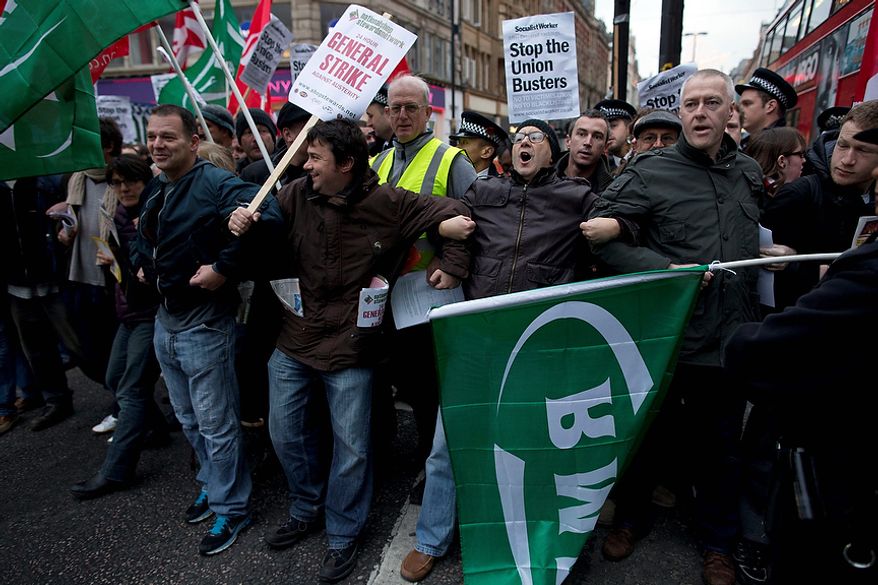 Protesters block traffic on one side of Oxford Street, London, whilst taking part in a picket and demonstration they said was over dismissals of 28 workers employed by contractors on the Crossrail transport project, for being trade union members, Wednesday, Nov. 14, 2012. The protest was held to coincide with planned European strikes on Wednesday in Spain, Italy, Greece, Portugal, France and Belgium against austerity measures and economic reforms. Crossrail, due to start running services in 2018, is a new train line that will include twin-bore 21 km tunnels under central London and link 37 stations including transport hubs such as Heathrow airport with business districts including the City and Canary Wharf. (AP Photo/Matt Dunham)