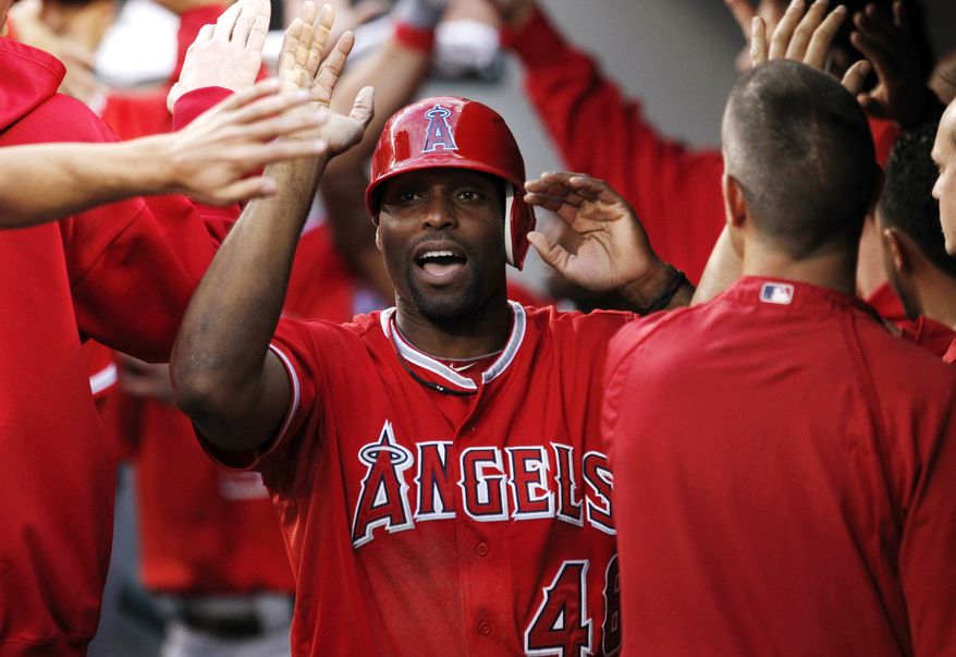 FILE - This Aug. 31, 2012 file photo shows Los Angeles Angels' Torii Hunter being congratulaed in the dugout during a baseball game against the Seattle Mariners in Seattle. A person with knowledge of the negotiations says free agent outfielder Hunter has agreed to a two-year deal with the Detroit Tigers. The person, who spoke Wednesday, Nov. 14, 2012, on condition of anonymity because no announcement has been made, says the deal is pending a physical. (AP Photo/Elaine Thompson, File)