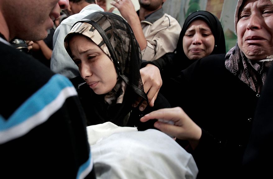 The parents of 11-month-old Palestinian baby Ahmed Masharawi, killed in an Israeli strike, hold his body during his funeral in Gaza City on Nov. 15, 2012. (Associated Press)