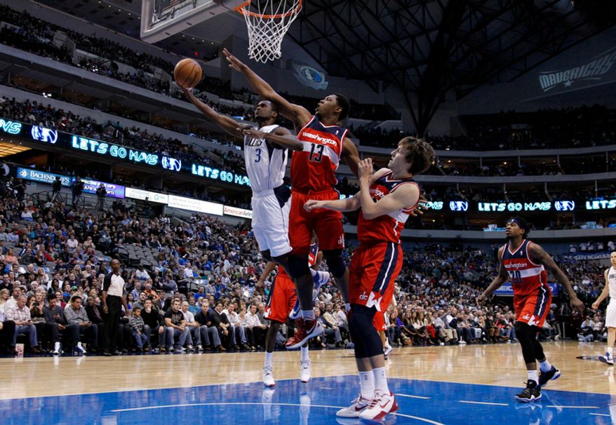 Dallas Mavericks&#39; Rodrigue Beaubois (3) of Guadeloupe attempts a shot as Washington Wizards&#39; Kevin Seraphin (13) of France and Jan Vesely, center right, defend during an NBA basketball game Wednesday, Nov. 14, 2012, in Dallas. The Mavericks won 107-101. (AP Photo/Tony Gutierrez)