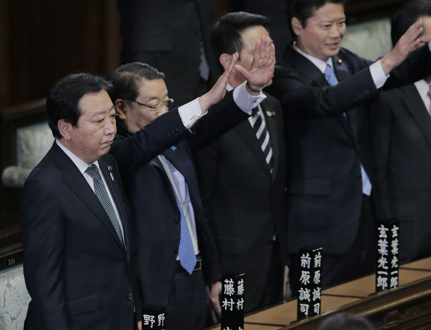 Prime Minister Yoshihiko Noda stands still as Chief Cabinet Secretary Osamu Fujimura, second left, and Foreign Minister Koichiro Gemba, right, raise hands and shout banzai, or long live, after he dissolved the lower house of parliament in Tokyo Friday, Nov. 16, 2012. (AP Photo/Koji Sasahara)