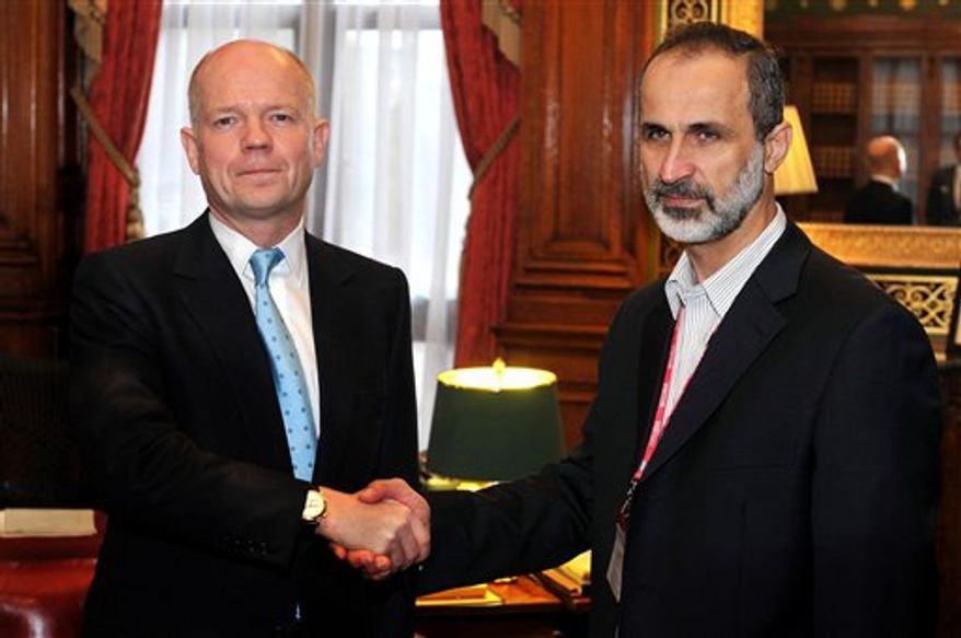 Britain's Foreign Secretary William Hague shakes hands for the cameras with the head of the new Syrian National Coalition for Opposition and Revolutionary Forces Mouaz al-Khatib before a meeting on the continuing conflict in Syria, at the Foreign and Commonwealth office in Whitehall central on Friday, Nov. 16, 2012. (AP Photo/ John Stillwell/Pool)
