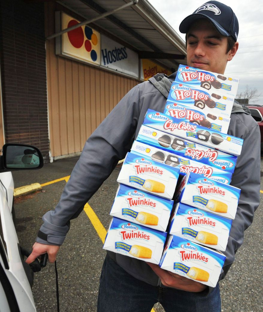 Andy Wagar loads some of the last Hostess products into a van outside the Wonder Bakery Thrift Shop in Bellingham, Wash., on Friday after the century-old company said it would shutter operations. (Associated Press)