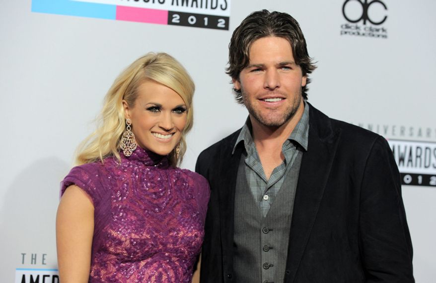 ** FILE ** Carrie Underwood, left, and Mike Fisher arrive at the 40th Anniversary American Music Awards on Sunday, Nov. 18, 2012, in Los Angeles. (Photo by Jordan Strauss/Invision/AP)