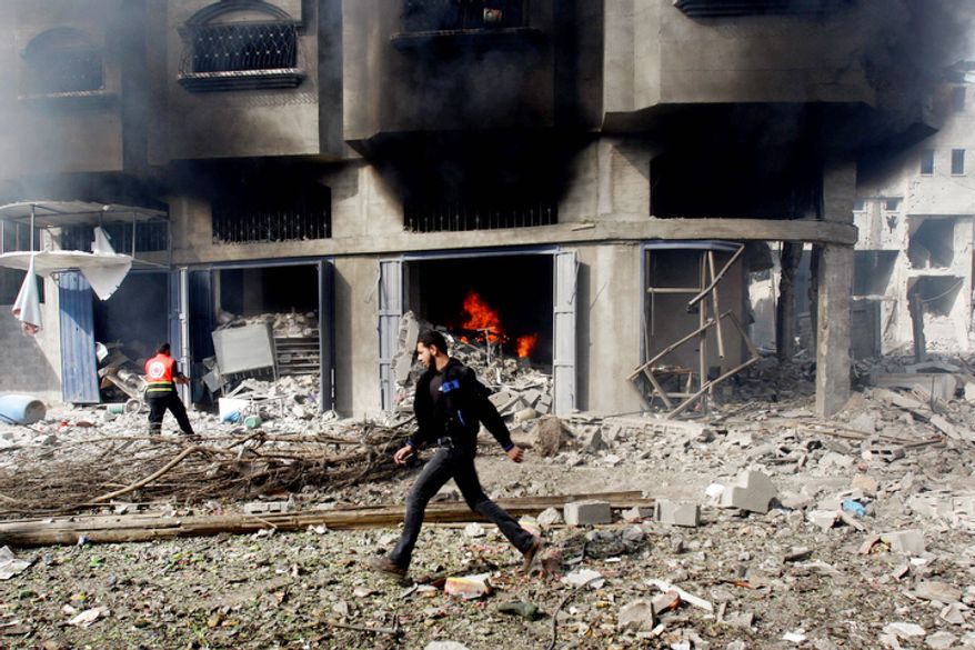 A Palestinian firefighter tries to extinguish a fire in the building following an Israeli air strike in Gaza City. (AP Photo/Adel Hana)