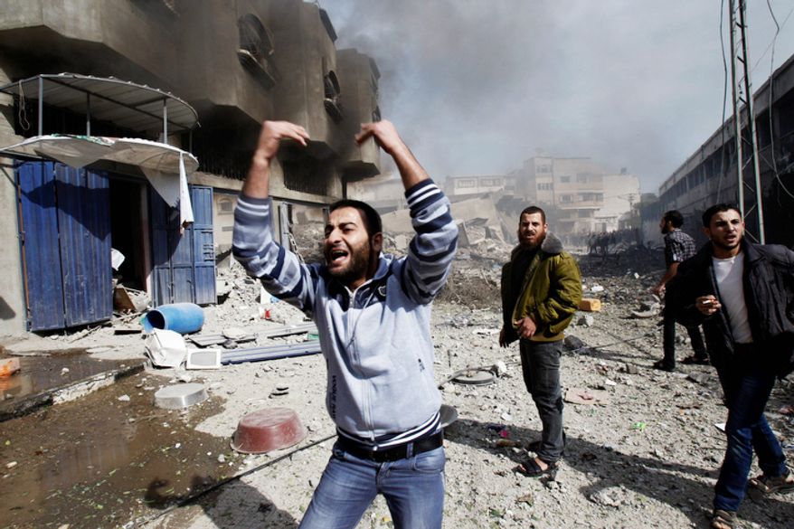 Palestinians call for help as they stand next to a damaged building after an Israeli air strike in Gaza City. (AP Photo/Adel Hana)