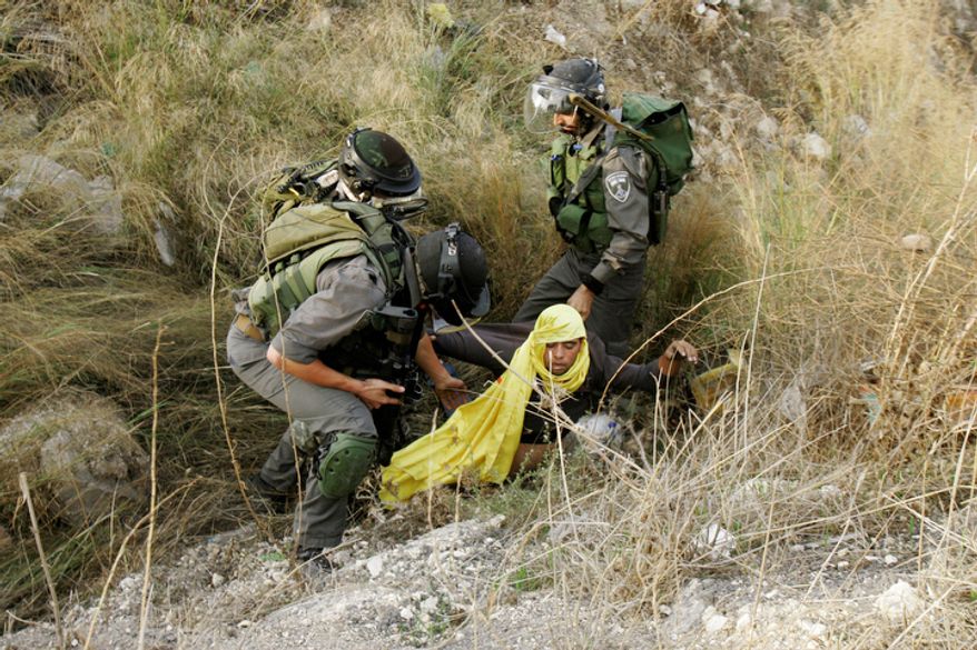 A Palestinian is arrested by Israeli security forces during a protest against the Israeli military operations in Gaza Strip near the West Bank city of Nablus, Sunday, Nov. 18, 2012. (AP Photo/Nasser Ishtayeh)