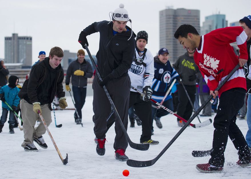 Winnipeg Jets captain Andrew Ladd, center, plays street hockey with hockey fans and a few fellow NHL players atop a parking garage at the Forks in Winnipeg, Manitoba, on Tuesday, Nov. 13, 2012. The lockout between the NHL and the players is in it's 59th day. (AP Photo/The Canadian Press, David Lipnowski)