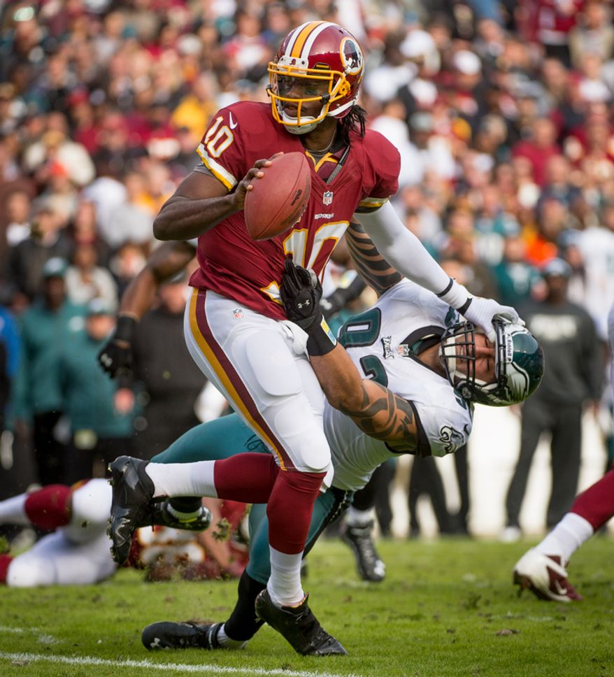 Washington Redskins quarterback Robert Griffin III (10) stiff arms Philadelphia Eagles defensive end Jason Babin (93) as he pitches out to Washington Redskins running back Alfred Morris (46) in the first quarter as the Washington Redskins play the Philadelphia Eagles at FedEx Field, Landover, Md., Sunday, Nov. 18, 2012. (Andrew Harnik/The Washington Times)