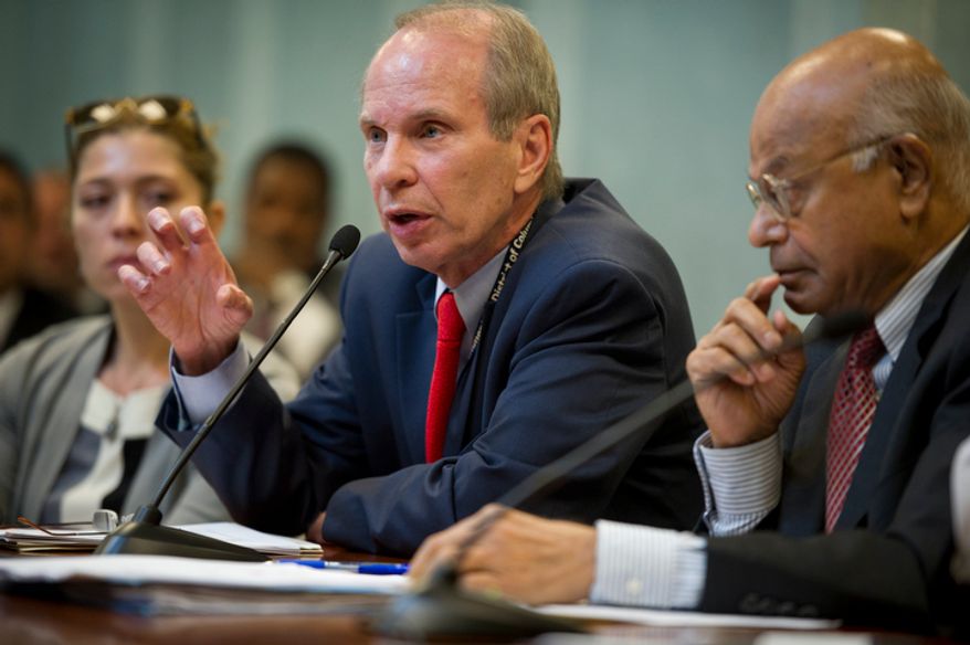 **FILE** Buddy Roogow (center), D.C. Lottery Executive Director, testifies June 29, 2011, at the Wilson Building in Washington, D.C., before a city council hearing regarding online poker in D.C. At right is Natwar M. Gandhi, D.C.'s Chief Financial Officer. (Rod Lamkey Jr/The Washington Times)