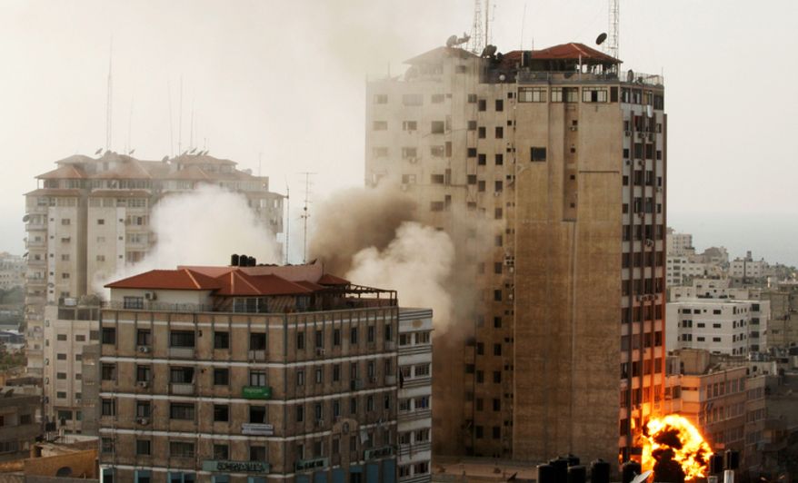 Smoke and fire are seen from an explosion by a high rise housing media organizations in Gaza City, Monday, Nov. 19, 2012. It's the Israel's military second strike on the building in two days. The Hamas TV station, Al Aqsa, is located on the top floor. (AP Photo/Hatem Moussa)
