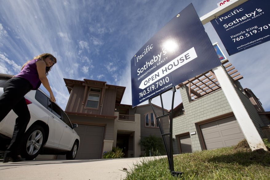 A woman walks towards a home for sale during a viewing for brokers in Leucadia, Calif., on Nov. 14, 2012. (Associated Press)
