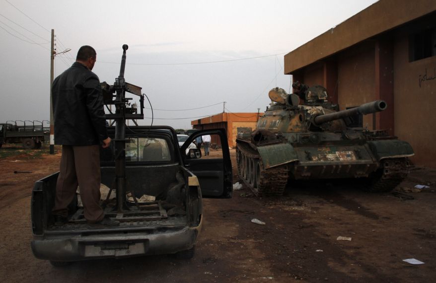 Syrian fighters celebrate victory atop a tank they took after storming a military base in Aleppo on Nov. 19, 2012. (Associated Press)