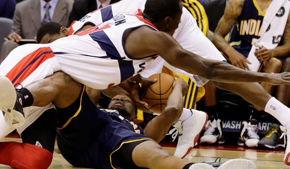 Washington Wizards center Earl Barron (top) dives for the ball as Indiana Pacers forward Sam Young holds on to it during the first half of the Pacers&#39; 96-89 road win on Nov. 19, 2012. (Associated Press)