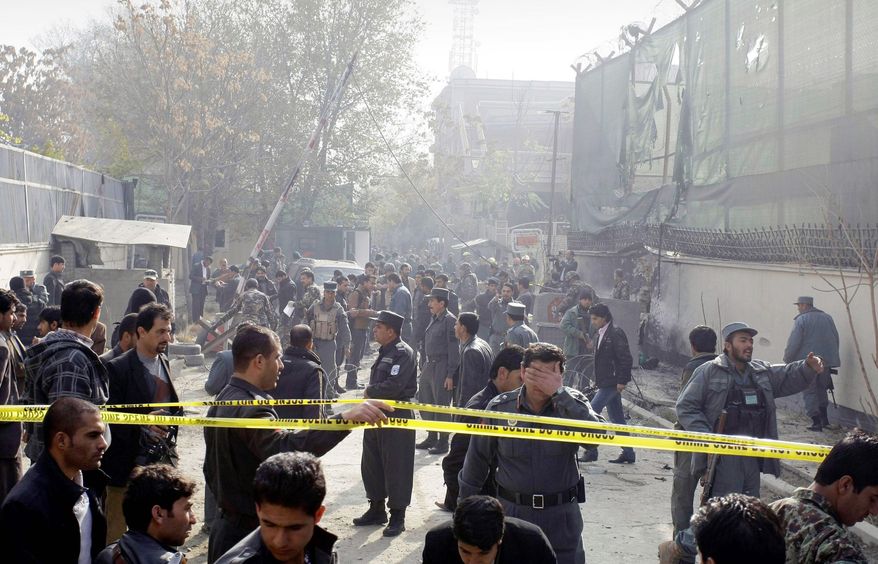 associated press
Afghan security men and media members gather at the scene of a suicide attack in Kabul, Afghanistan, on Wednesday. A man wearing a suicide vest blew himself up near a U.S. base in the capital early Wednesday. Two guards were killed.