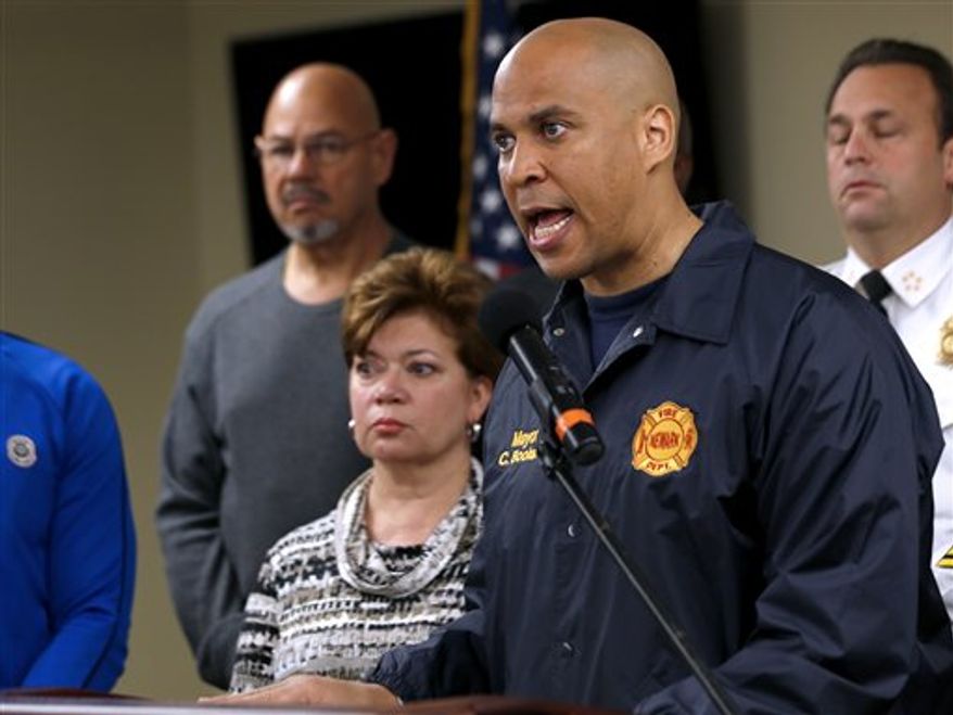 ** FILE ** In this Oct. 29, 2012, photo, Newark Mayor Cory Booker, right, speaks during a news conference at the Office of Emergency Management in Newark, N.J. Booker says he plans to honor a Twitter challenge and live on food stamps for at least a week. In a Twitter exchange Sunday, Nov. 18, 2012, Booker and a user named TwitWit discussed government funding for school meals. Booker suggested they both try living on food stamps for a week or month. (Associated Press)