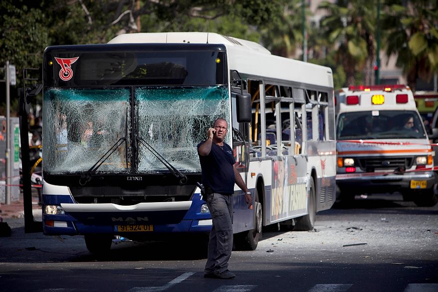 An Israeli security officer stands next to a blown up bus at the site of a bombing in Tel Aviv, Israel, Wednesday, Nov. 21, 2012. A bomb ripped through an Israeli bus near the nation's military headquarters in Tel Aviv on Wednesday, wounding several people, Israeli officials said. The blast came amid a weeklong Israeli offensive against Palestinian militants in Gaza. (AP Photo/Oded Balilty)