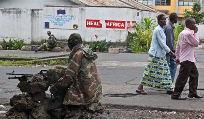 People walk past as M23 rebel soldier&#x27;s take positions near the Heal Africa hospital in the center of Goma, Congo, Tuesday, Nov. 20, 2012. (AP Photo/Melanie Gouby)
