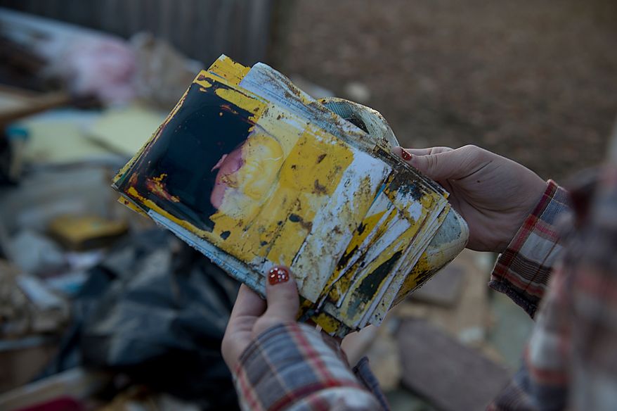 Abbi Audas checks finds family photos that have been damaged from Hurricane Sandy in Union Beach, N.J. on Wednesday, Nov. 21, 2012. They have donated items here that they collected in Project Keep Them Cozy, which Abbi, 12, and Andrew, 9, spearheaded. The family is spending their Thanksgiving up here volunteering. (Barbara L. Salisbury/The Washington Times)