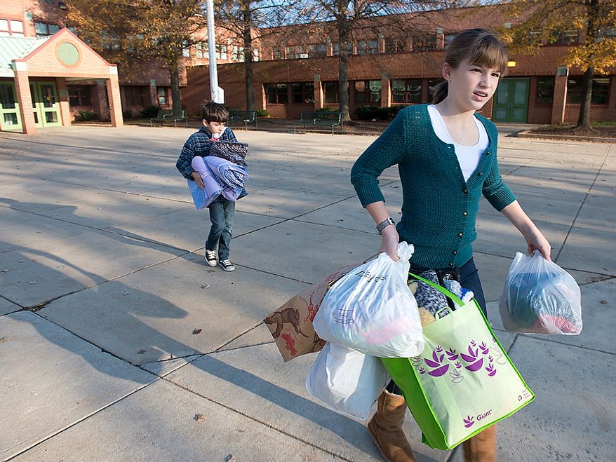 Abbi Audas, right, 12, and her brother Andrew, 9, carry donated items out of Abbi's school, Pyle Middle School in Bethesda, Md., on Wednesday, Nov. 14, 2012. The Audas children placed donation boxes at each of their schools for "Project Keep Them Cozy," asking people to donate items for Hurricane Sandy victims. The family will drive all of the donated items to New Jersey on Wednesday and then stay through the Thanksgiving holiday to volunteer. (Barbara L. Salisbury/The Washington Times)