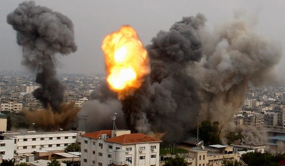 Smoke and a ball of fire are seen after an Israeli air strike in Gaza City, Wednesday, Nov. 21, 2012. Israeli aircraft pounded Gaza with at least 30 strikes overnight, hitting government ministries, smuggling tunnels, a banker&#39;s empty villa and a Hamas-linked media office.  (AP Photo/Hatem Moussa)