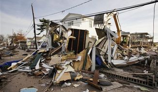 Backhoe operator Keith Henry levels a storm-damaged home in the Breezy Point section of the Queens borough of New York, Tuesday, Nov. 20, 2012. (AP Photo/Mark Lennihan)

