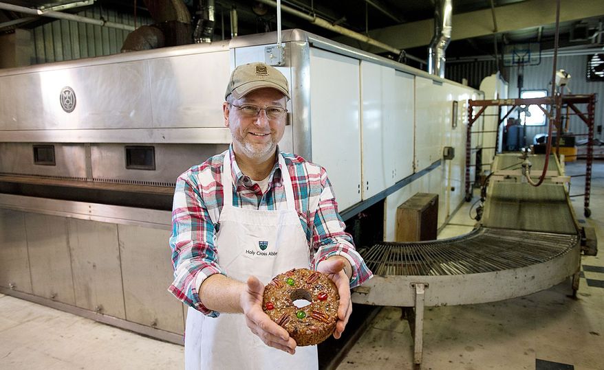 Ernie Polanskas, bakery manager at the Holy Cross Abbey in Berryville, Va., holds one of the 10,000 fruitcakes the abbey sells to buyers all over the world yearly. Mr. Polanskas does his baking in a huge industrial-sized oven the abbey bought back in the 1960s to bake bread before switching to fruitcake production. (Barbara L. Salisbury/The Washington Times)