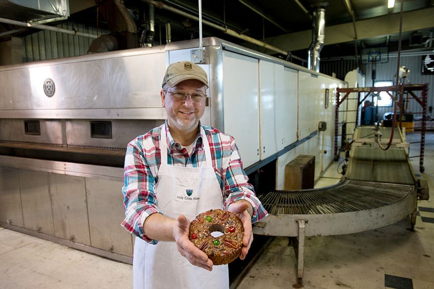 Ernie Polanskas, bakery manager at the Holy Cross Abbey bakery in Berryville, Va., holds one of the famous fruitcakes made by the monks in front of the huge industrial-sized oven that they bought back in the 1960s to bake bread. The monks bake from January to September, making about 10,000 fruitcakes, which they ship all over the world, primarily during the holiday season. The proceeds from the sales go to support the day-to-day operations of the monastery. This image was made Tuesday, Nov. 13, 2012. (Barbara L. Salisbury/The Washington Times)