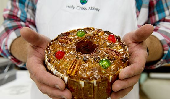 Ernie Polanskas, bakery manager at the Holy Cross Abbey bakery in Berryville, Va., holds one of the famous fruitcakes made by the monks on Tuesday, Nov. 13, 2012. He says that they use a recipe that they got from Betty Crocker back in the 1960s which they have tweaked a little over the years. Their fruitcake is two-thirds candied fruits and nuts, and he says this fact, along with the fact that they steam it while they bake it, keeps it really moist.  (Barbara L. Salisbury/The Washington Times)