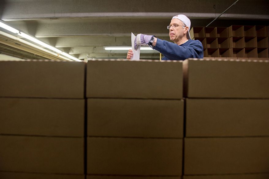 Surrounded by boxes of packaged fruitcakes, Brother Christopher Harmon puts shipping labels on more boxes to be shipped from the Holy Cross Abbey in Berryville, Va. on Monday, Nov. 19, 2012. The monks have been making fruitcakes for nearly 40 years and sell them as a means of making money for the day-to-day operations of the monastery. They bake from January to September, with Christmas being their busiest shipping time of year. (Barbara L. Salisbury/The Washington Times)