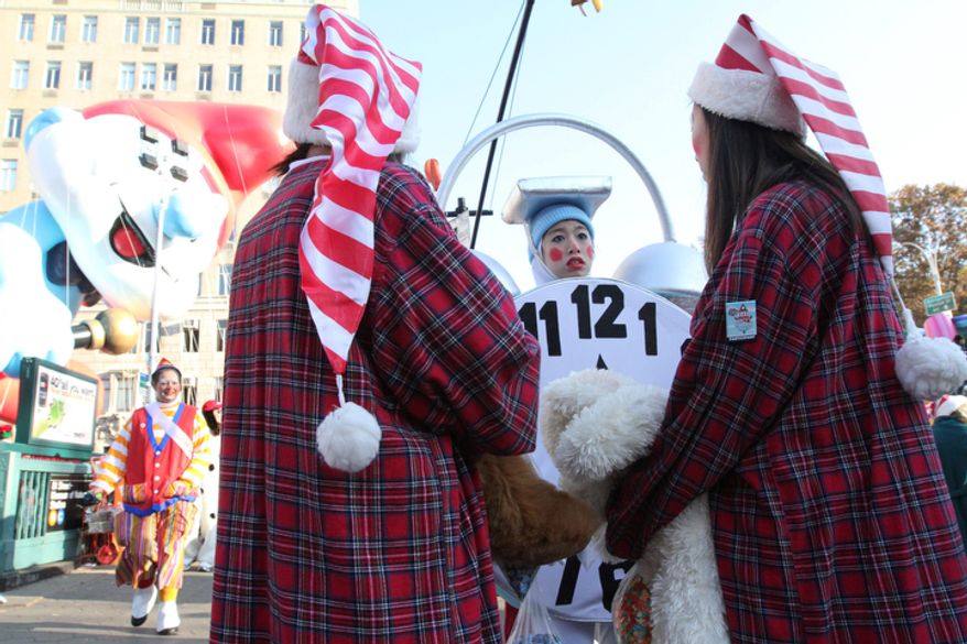 Dressed as a clock, Amy Allaire, of Norwich, N.Y., foreground center, waits with others to take part in the 86th Annual Macy's Thanksgiving Day Parade Thursday Nov. 22, 2012, in New York. The annual Macy's Thanksgiving Day Parade put a festive mood in the air in a city still coping with the aftermath of Superstorm Sandy. (AP Photo/Tina Fineberg)