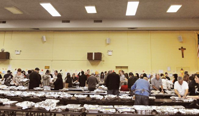 Volunteers assemble Thanksgiving dinners at St. Charles Church, which acted as a major hub for supplying turkey dinners on New York&#x27;s Staten Island, Thursday, Nov. 22, 2012. Volunteers served thousands of turkey dinners to people left homeless or struggling from Superstorm Sandy. (AP Photo/Stephanie Keith)