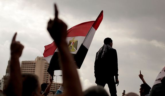 Egyptian protesters chant anti-government slogans and wave a national flag in Tahrir Square, Friday, Nov. 23, 2012. Supporters and opponents of Egypt&#39;s Islamist President Mohammed Morsi staged rival rallies Friday after he assumed sweeping new powers, a clear show of the deepening polarization plaguing the country. In a Thursday, Nov. 22, 2012 decree Morsi put himself above the judiciary and also exempted the Islamist-dominated constituent assembly writing Egypt&#39;s new constitution from judicial review. (AP Photo/Maya Alleruzzo)