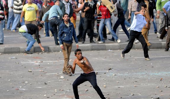 Protesters hurl stones during clashes between supporters and opponents of President Mohammed Morsi in Alexandria, Egypt, Friday, Nov. 23, 2012. Opponents and supporters of Mohammed Morsi clashed across Egypt on Friday, the day after the president granted himself sweeping new powers that critics fear can allow him to be a virtual dictator. Thousands from the two camps threw stones and chunks of marble at each other outside a mosque in the Mediterranean city of Alexandria after Friday Muslim prayers.(AP Photo/Tarek Fawzy)