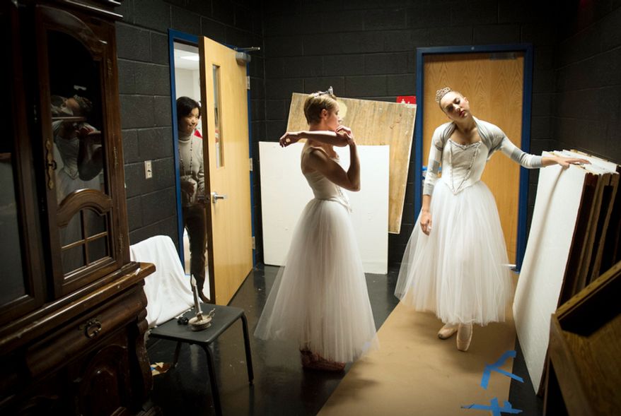 Dancers Ariane Georg (left) and Emily Bond (right) stretch in a side room off stage prior to their performance of The Nutcracker at W.T. Woodson High School in Fairfax, Va., Sunday, Nov. 25, 2012. (Rod Lamkey Jr./The Washington Times)