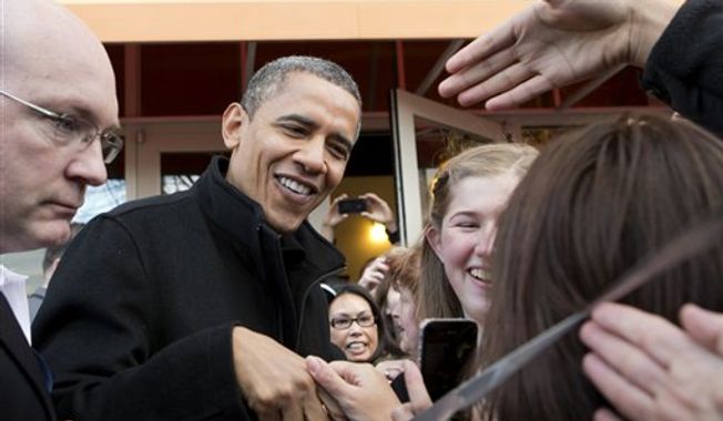 President Obama shakes hands outside a small bookstore in Arlington, Va., Saturday, Nov. 24, 2012, where he went shopping with his daughters. (AP Photo/J. Scott Applewhite)