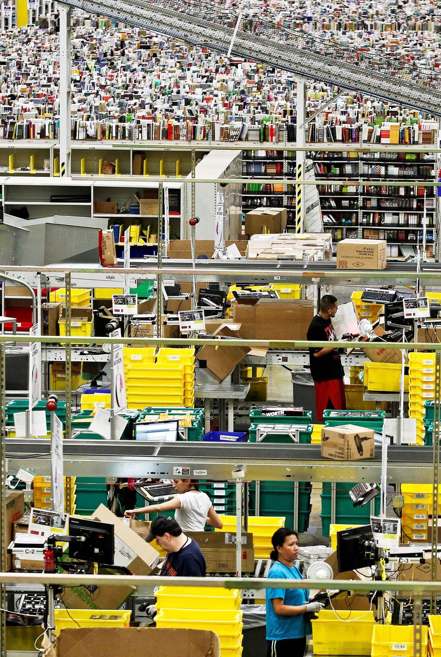 Workers pull merchandise Monday at the Amazon.com 1.2 million-square-foot fulfillment center in Phoenix. Americans clicked away on their computers and smartphones for deals on so-called Cyber Monday, which was expected to end as the biggest online shopping day in history. Shoppers were expected to spend $1.5 billion, up 20 percent from last year. (Associated Press)