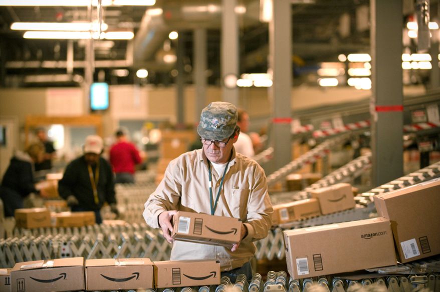 An Amazon.com employee grabs boxes off the conveyor belt to load into a truck at the company's Fernley, Nev., warehouse on Monday, Dec. 1, 2008. "Cyber Monday," coined in 2005 by a shopping trade group that noticed a spike in online sales on the Monday after Thanksgiving when people returned to their work computers, is the next in a line of days that stores are counting on to jump-start the holiday shopping season. This year it is expected to be the biggest online shopping day of the year for the third year in a row. (AP Photo/Scott Sady)