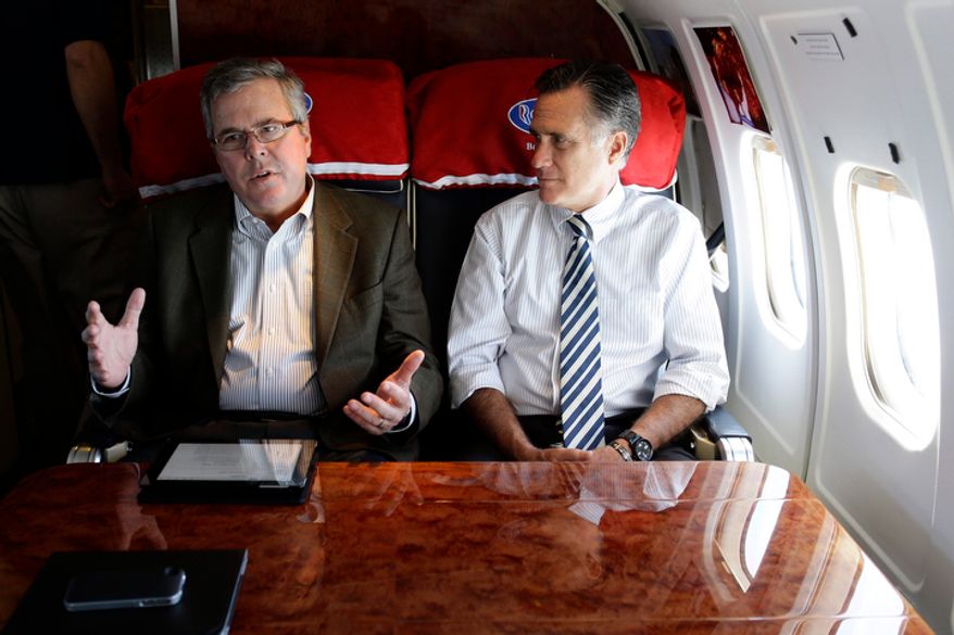 Republican presidential candidate Mitt Romney (right) talks with former Florida Gov. Jeb Bush as they fly on Mr. Romney&#39;s campaign plane to Miami on Wednesday, Oct. 31, 2012. (AP Photo/Charles Dharapak) ** FILE **