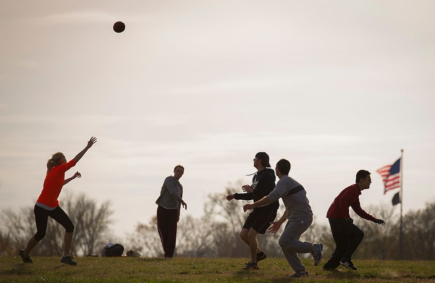 Friends play a game of tag football in the shadow of the Washington Monument as mild temperatures prevailed in Washington on Sunday, Nov. 18, 2012. (Rod Lamkey Jr./The Washington Times)