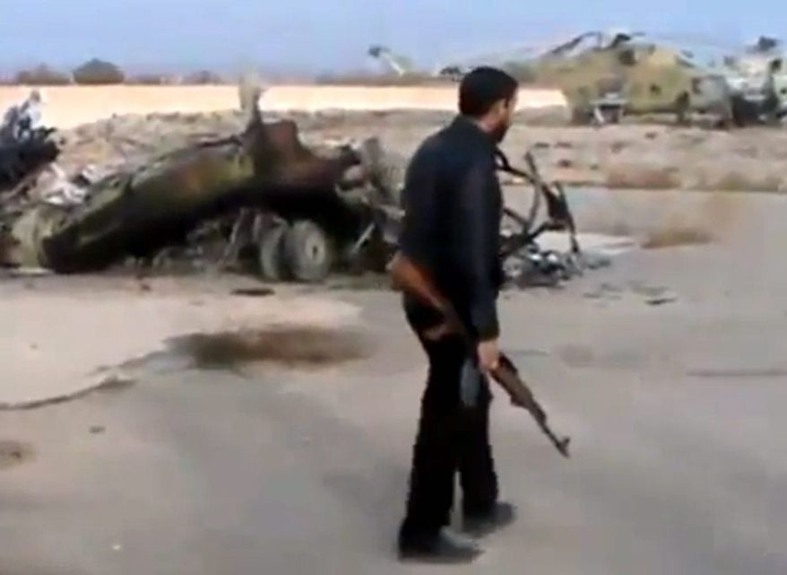 In this image taken from video obtained from the Ugarit News, which has been authenticated based on its contents and other AP reporting, Syrian rebels capture a helicopter air base near the capital, Damascus, after fierce fighting on Sunday, Nov. 25, 2012. The takeover claim showed how rebels are advancing in the area of the capital, though they are badly outgunned by President Bashar Assad's forces, making inroads where Mr. Assad's power was once unchallenged. Rebels have also been able to fire mortar rounds into Damascus recently. (AP Photo/Ugarit News via AP video)