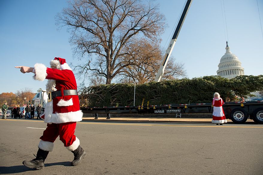 Santa and Mrs. Claus, played by Gerald and Twila Morris, arrive with a 9,000-pound, 74-year-old, 73-foot Engelmann spruce, driven 5,500 miles from White River National Forest in Meeker, Colo., that will be moved into position on the West Lawn of the U.S. Capitol as this year's Capitol Christmas Tree, in Washington on Monday, Nov. 26, 2012. (Andrew Harnik/The Washington Times)
